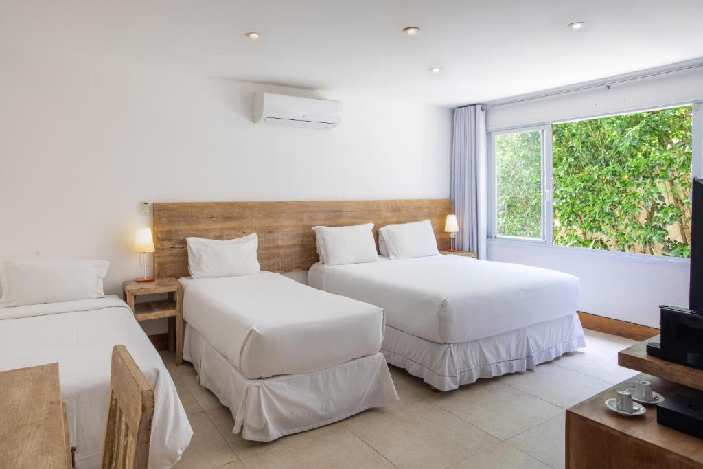 una camera d'albergo con due letti e una finestra di O HOTEL a Búzios