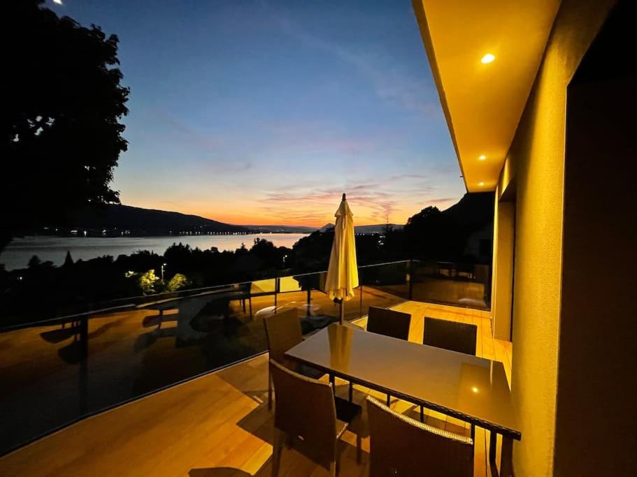- Balcón con mesa de comedor y sillas y puesta de sol en Le cocon du lac, en Veyrier-du-Lac