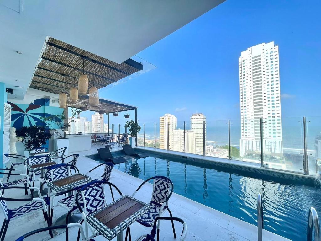 a swimming pool with chairs and a view of the city at Hotel Zi One Luxury in Cartagena de Indias