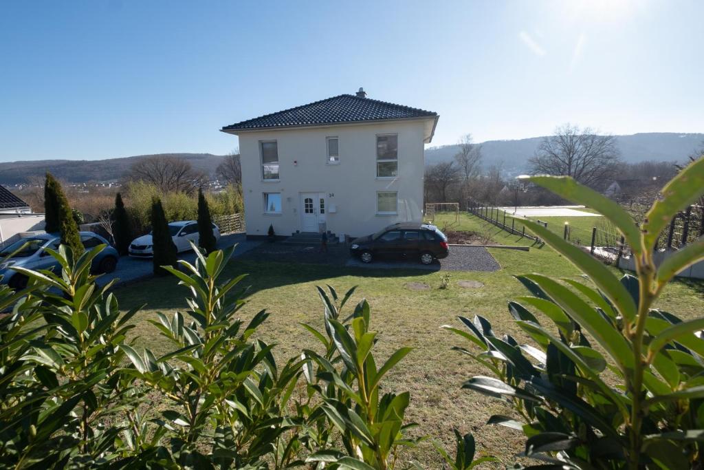 a white house with a car parked in a yard at Top Wohnung mit traumhaftem Fernblick in 1A-Lage! in Hagen