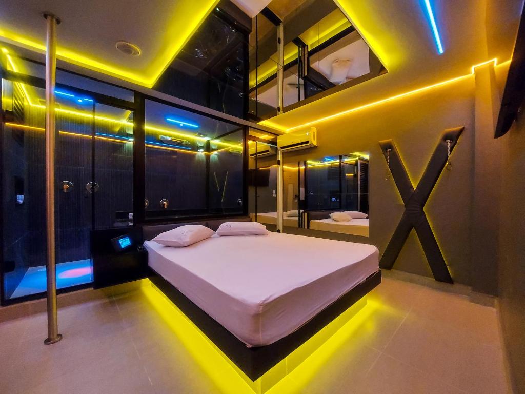 um quarto com uma grande cama branca com luzes amarelas em Adrenalina Motel Itaquera - Arena Corinthians em São Paulo