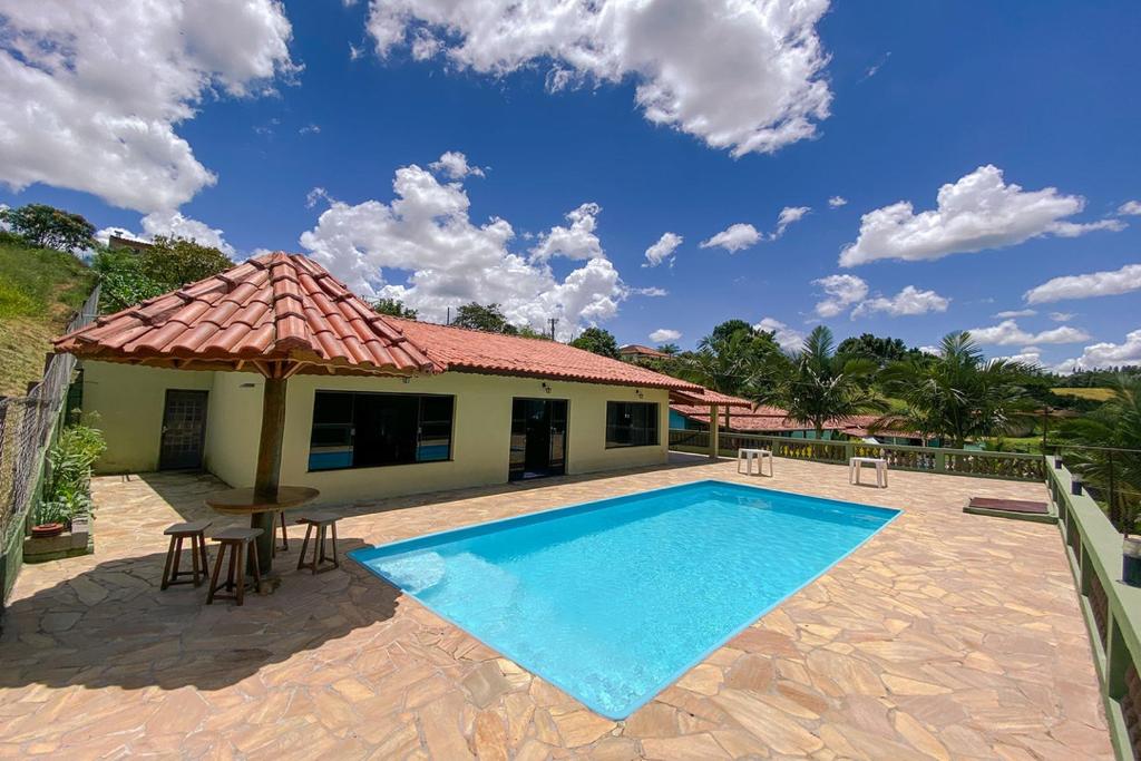 eine Villa mit einem Pool und einem Haus in der Unterkunft Chacara com churrasq, piscina e lazer - Socorro SP in Socorro