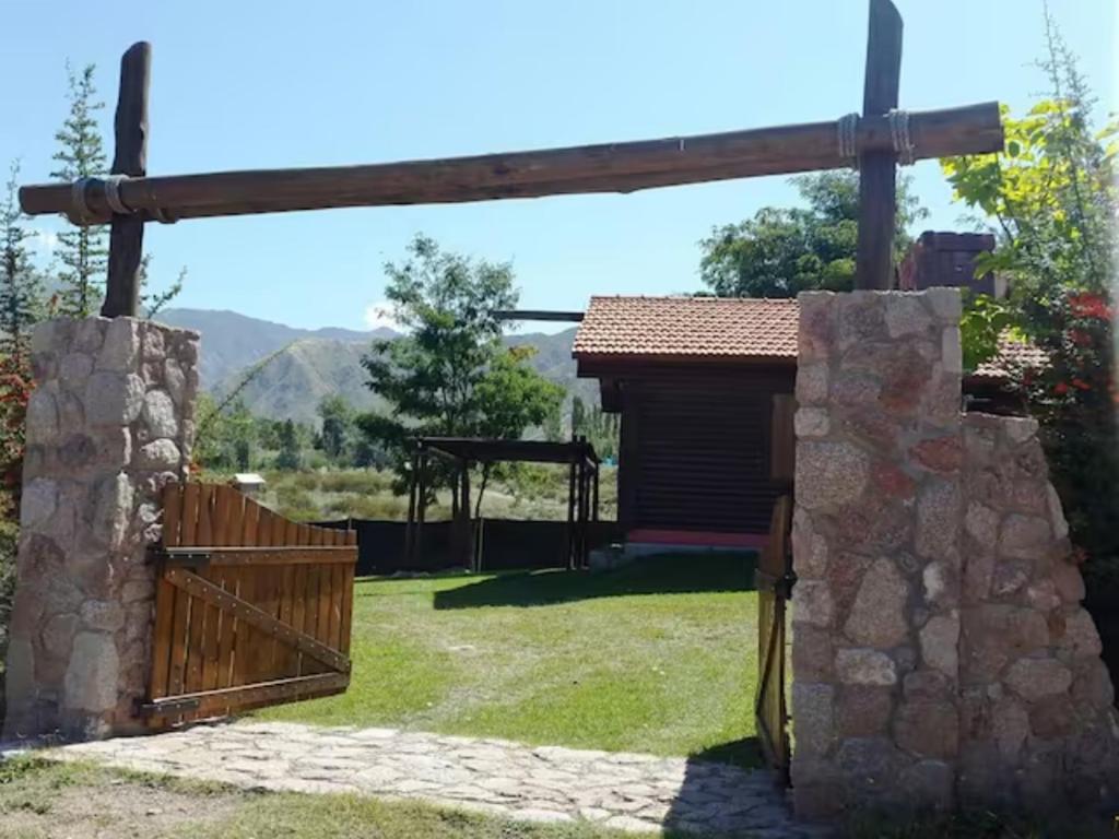 a wooden gate in a yard with a stone fence at Solares de Cacheuta in Cacheuta