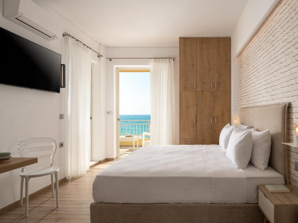 a bedroom with a bed and a view of the ocean at Unique seaside apartment in Rethymno Town