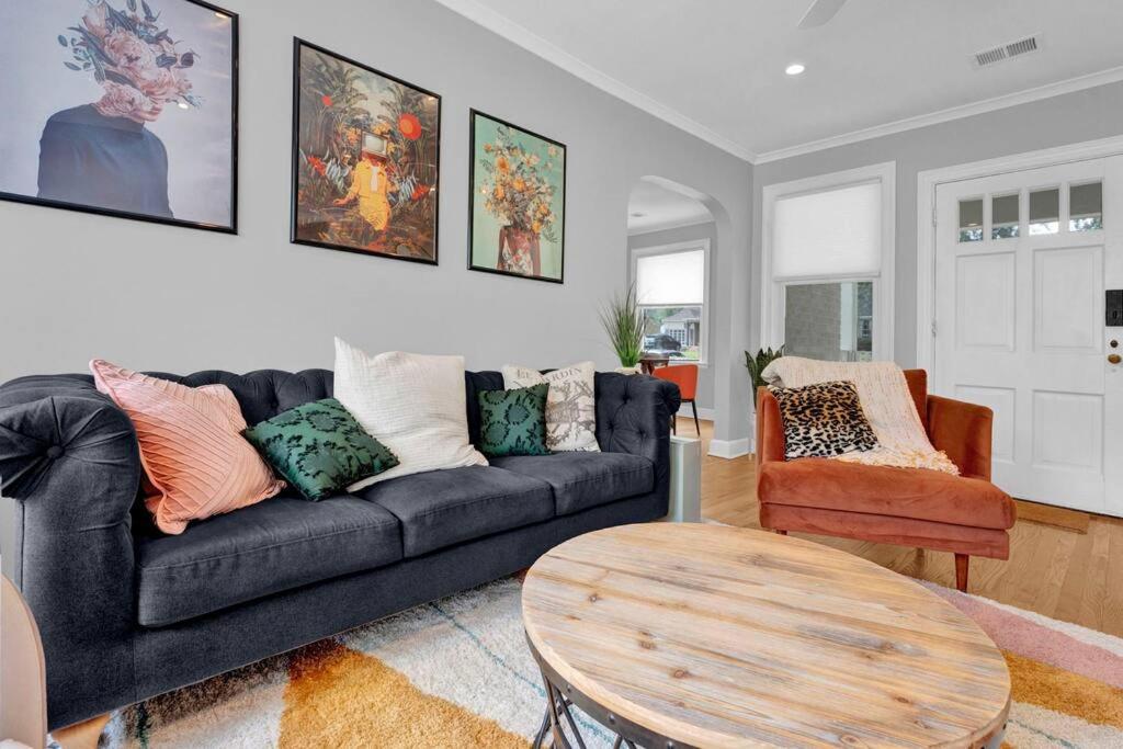 a living room with a black couch and a table at High Point Terrace Bungalow in Memphis