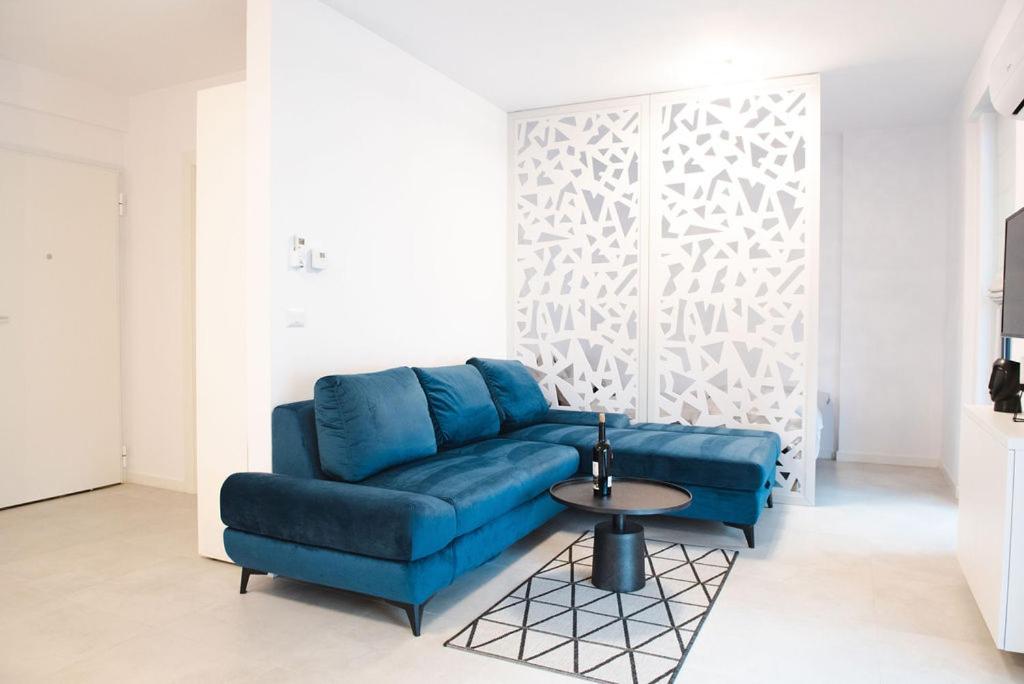 a blue couch in a living room with a table at Alternativ 1 Residence in Timişoara