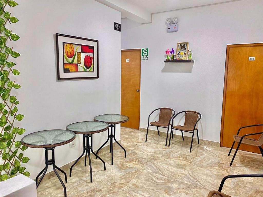 a waiting room with two tables and chairs at CASA SHILCAYO Habitaciones Vacacionales in Tarapoto