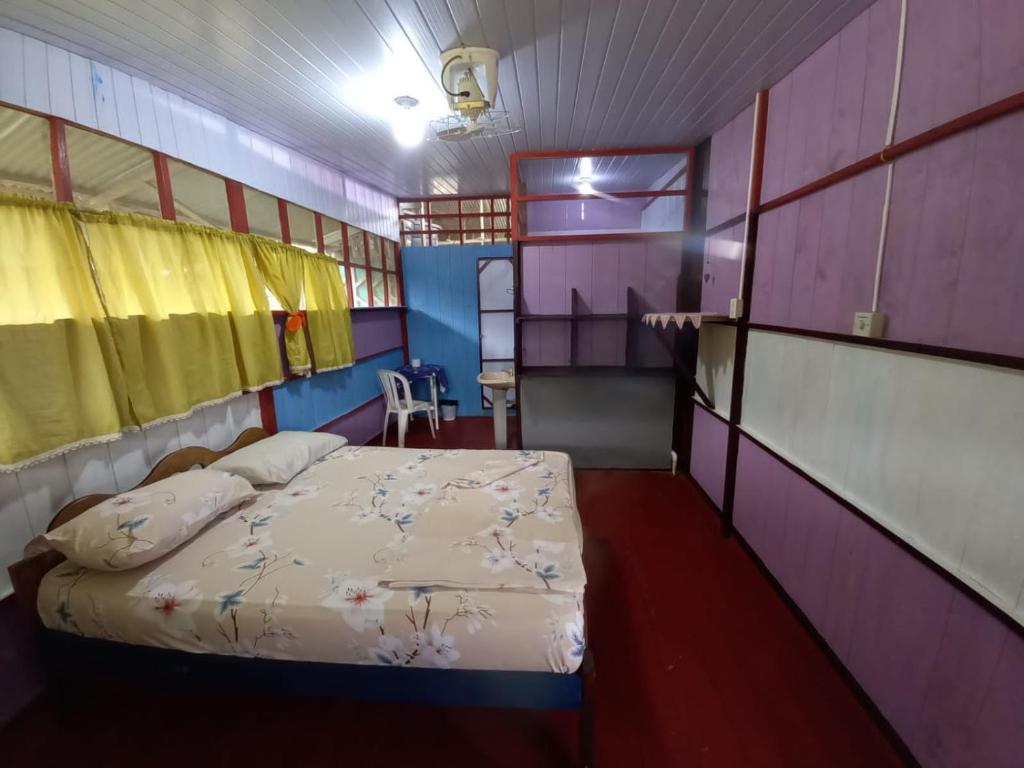 una camera con letto in una camera viola di Hostal tachiwa a Puerto Nariño