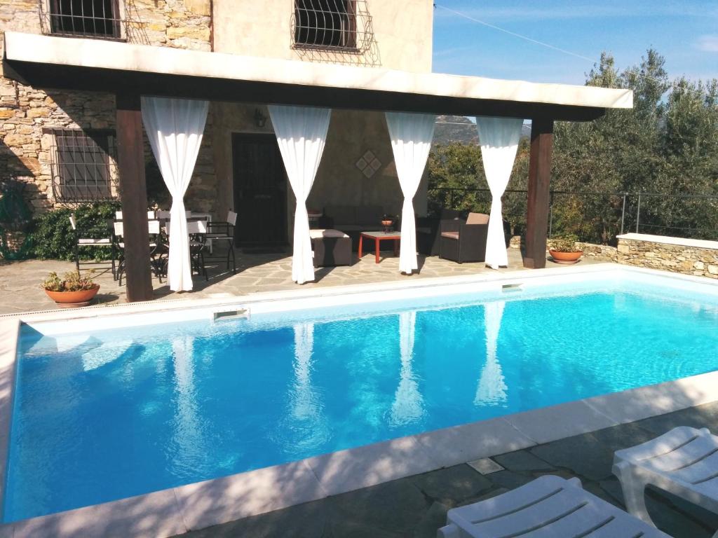 uma piscina com um gazebo com água azul em Il Portico Suite de Charme em Vescina