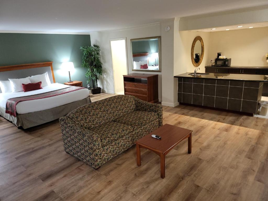 a hotel room with a bed and a couch at Ramada by Wyndham Houston Intercontinental Airport East in Humble