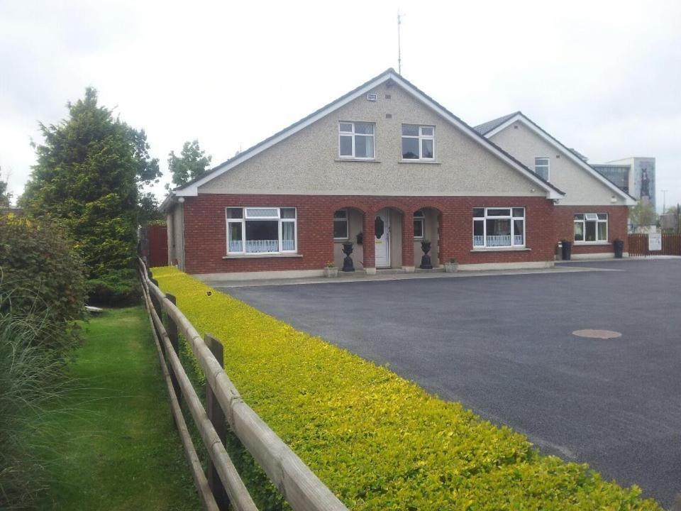a red brick house with a driveway in front of it at GoldenDawn Guest House in Citywest