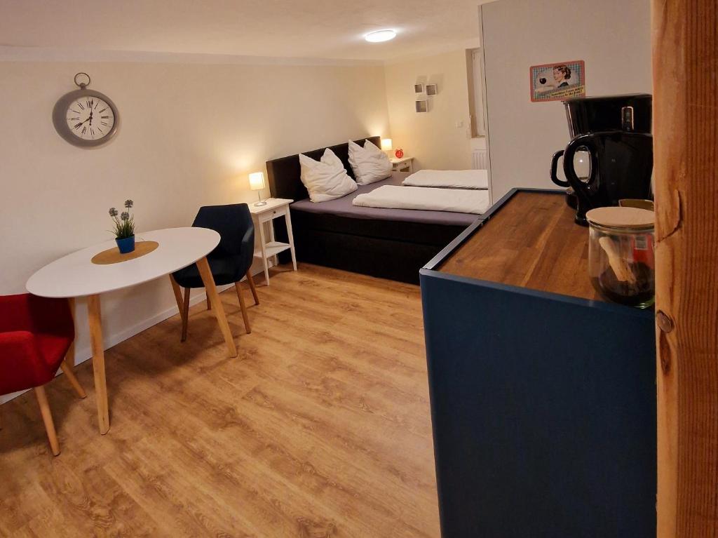 una pequeña sala de estar con cama y mesa. en Schönes Apartment in Niebüll, en Niebüll