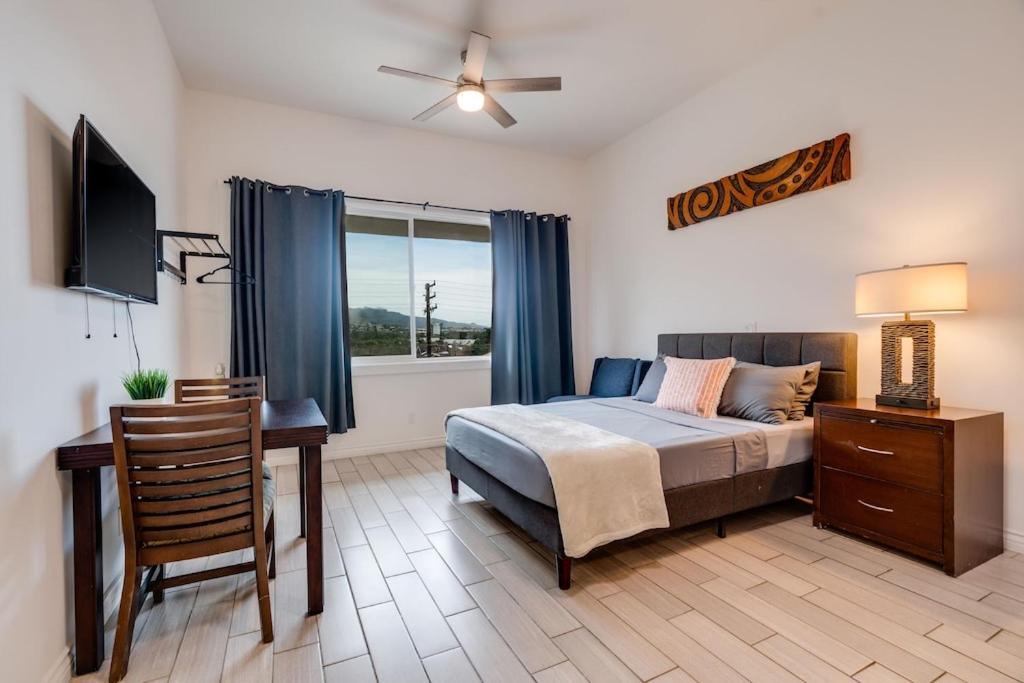 a bedroom with a bed and a desk and a window at Unit 14 Maui Ohana Modern Studio in Wailuku