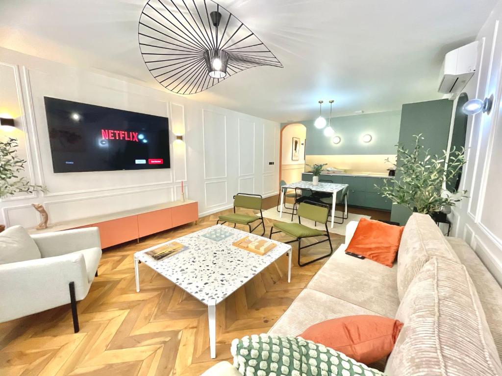 a living room with a couch and a tv at Les 3 arches - Grenoble in Grenoble