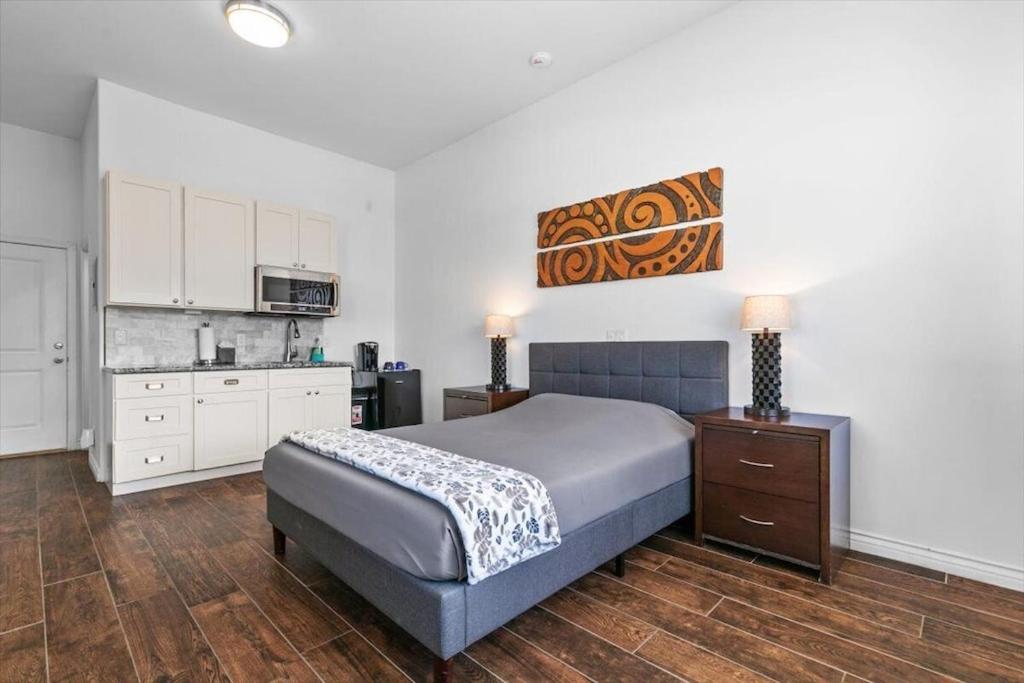 a bedroom with a large bed and a kitchen at Unit 15 Maui Ohana Modern Studio in Wailuku