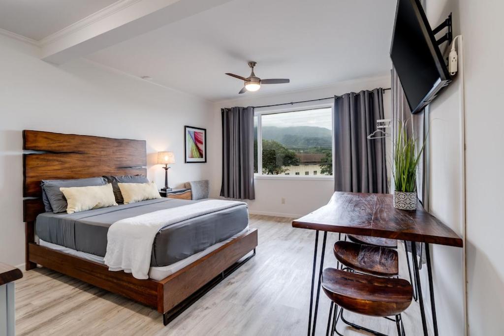 a bedroom with a bed and a large window at Unit 16 Maui Ohana Modern Studio in Wailuku