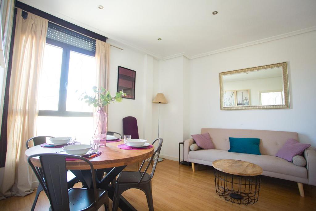 sala de estar con mesa y sofá en Apartament Glorieta Puerta de Toledo en Madrid