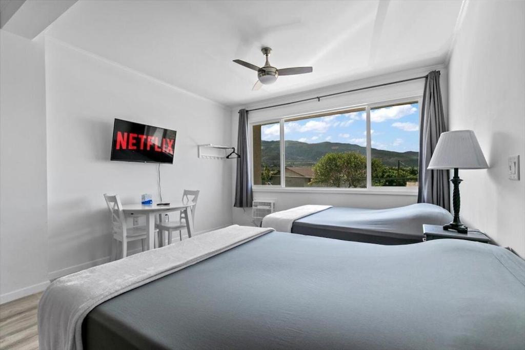 a hotel room with two beds and a window at Unit 17 Maui Ohana Modern Studio in Wailuku
