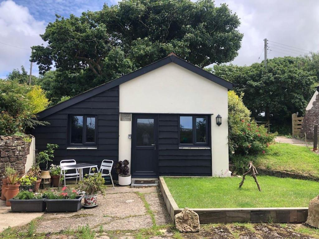 a black and white tiny house with a yard at Cosy cottage near Hartland Village in Bideford