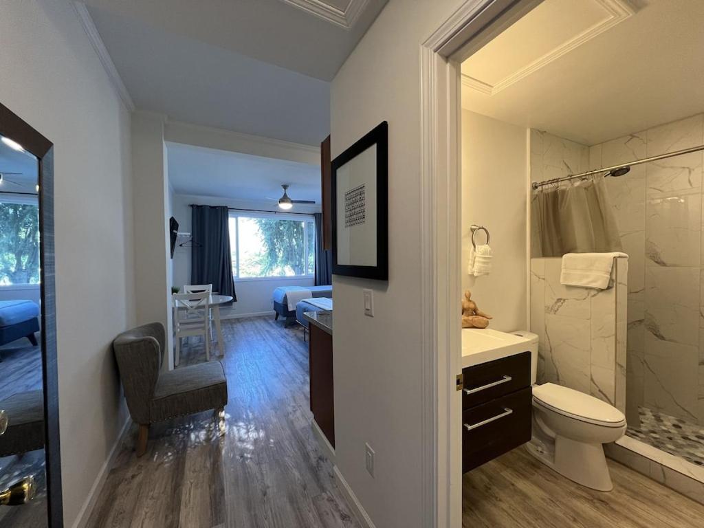 a bathroom with a toilet and a sink and a bathroom with a bed at Unit 19 Maui Ohana Modern Studio in Wailuku