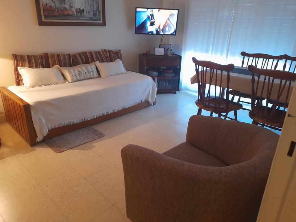 1 dormitorio con 1 cama, mesa y sillas en Departamento en barrio Stella Maris-Zona Playa Varese en Mar del Plata