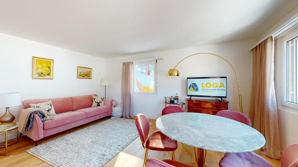 - un salon avec un canapé rose et une table dans l'établissement Abitaziun Ruinatsch 19A - St Moritz, à Saint-Moritz
