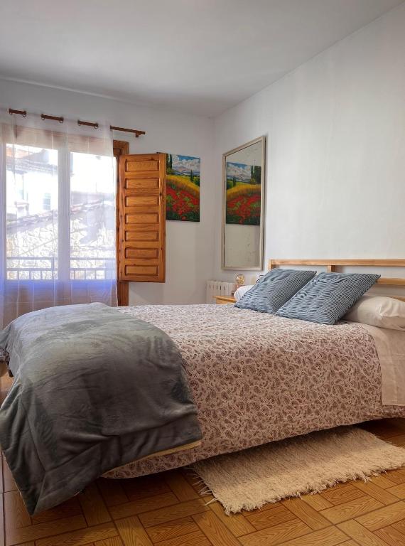 a bedroom with a large bed and a window at LA COLMENA in Cañizares