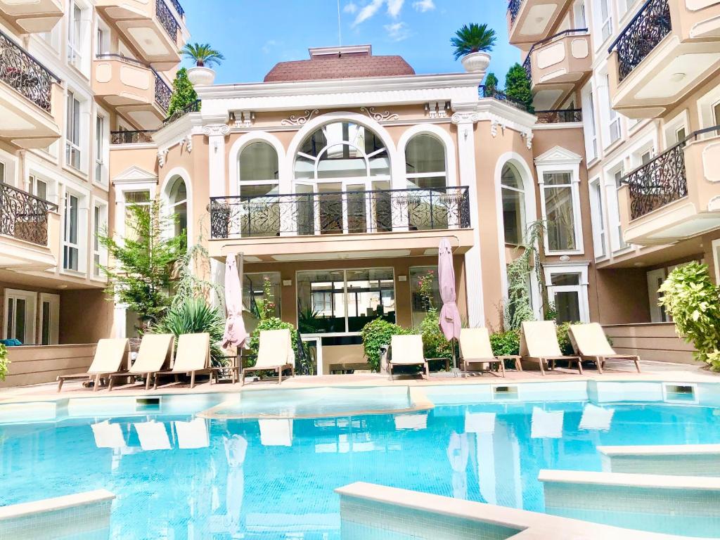 a house with a swimming pool in front of a building at Menada Apartments in Dawn Park Delux in Sunny Beach