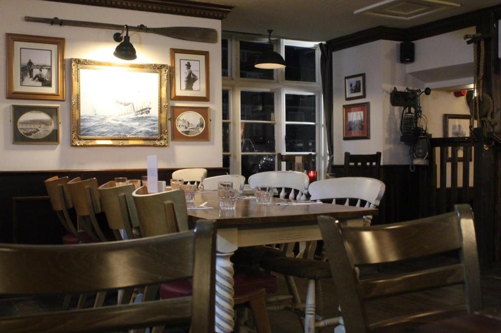 a dining room with a long table and chairs at Bridport Arms Hotel in West Bay