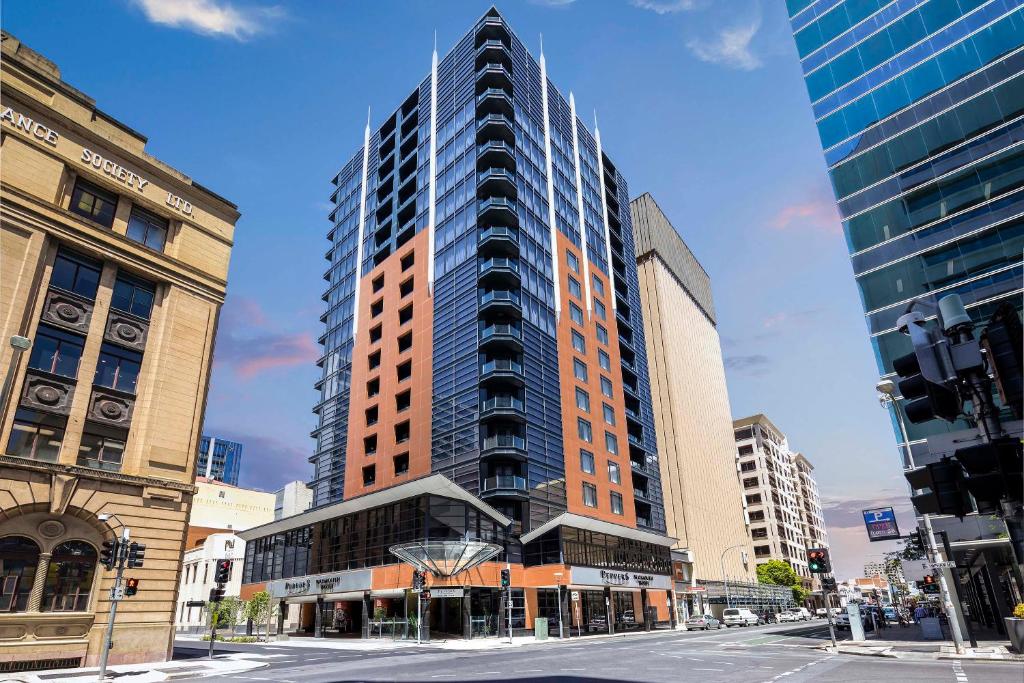 a tall building in the middle of a city at Peppers Waymouth Hotel in Adelaide