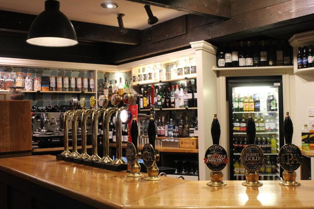a bar with a lot of bottles of alcohol at Bridport Arms Hotel in West Bay
