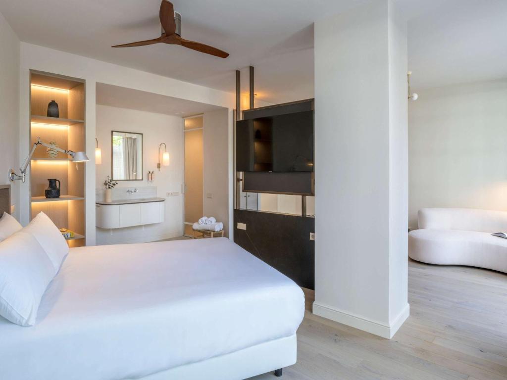 a bedroom with a white bed and a ceiling fan at Mercure Benidorm in Benidorm