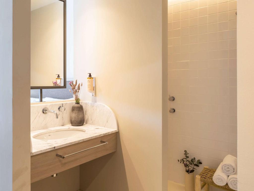 a bathroom with a sink and a mirror at Mercure Benidorm in Benidorm