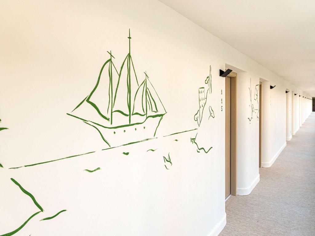 a room with a drawing of a sailboat on the wall at Mercure Benidorm in Benidorm