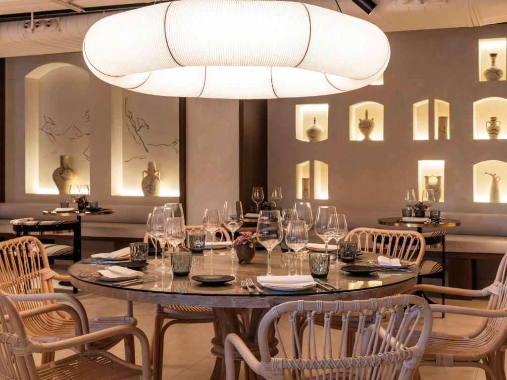 a dining room with a table and chairs and a chandelier at Mercure Benidorm in Benidorm