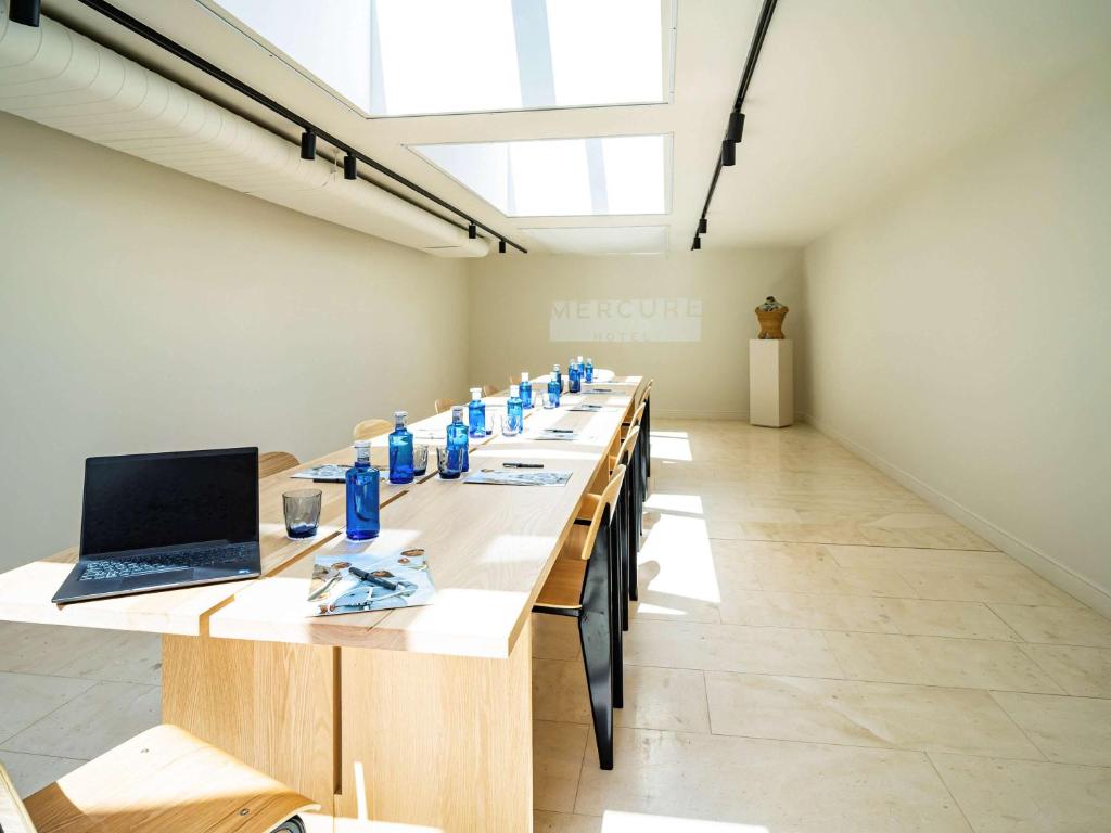 a long room with a long table with a laptop on it at Mercure Benidorm in Benidorm