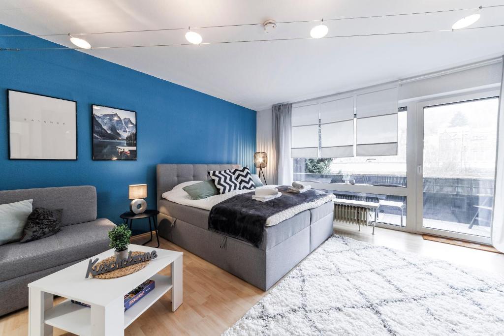 um quarto com uma cama e uma parede azul em DEHOME - Laguna - Stay by Central Station em Koblenz