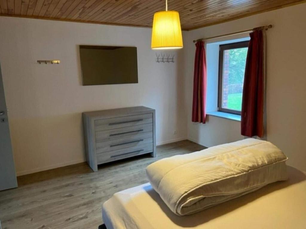 a bedroom with a bed and a tv and a window at Lovely holiday home in Gouvy with sauna in Gouvy