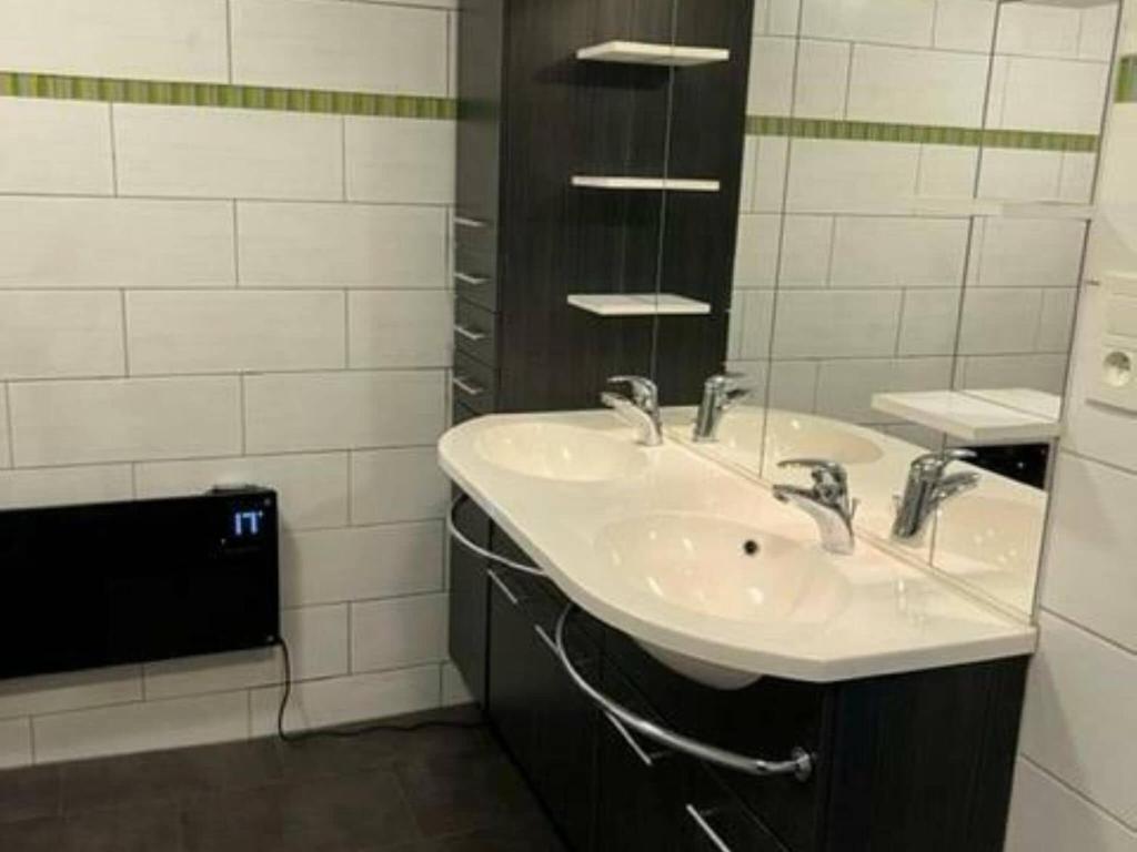 a bathroom with two sinks and a mirror at Lovely holiday home in Gouvy with sauna in Gouvy