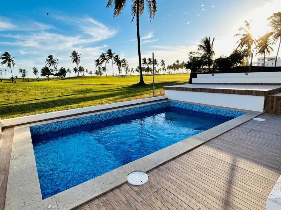 een zwembad in een achtertuin met palmbomen bij Estrella del mar · Hermosa casa vacacional in Barrón