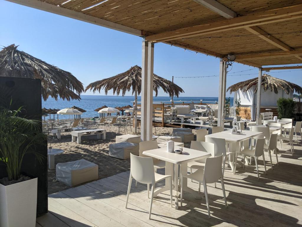 ein Restaurant mit Tischen und Stühlen am Strand in der Unterkunft Apartamento Davoli Marina in Marina di Davoli