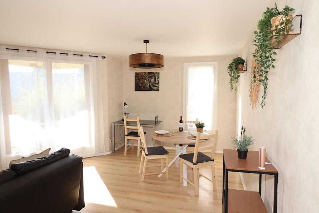 a living room with a couch and a table at Votre confort la Cosy Cocoon in Courcouronnes
