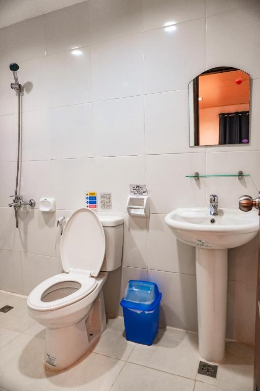 un baño con inodoro y lavabo en A&A ABE BAYFRONT INN, en Corón