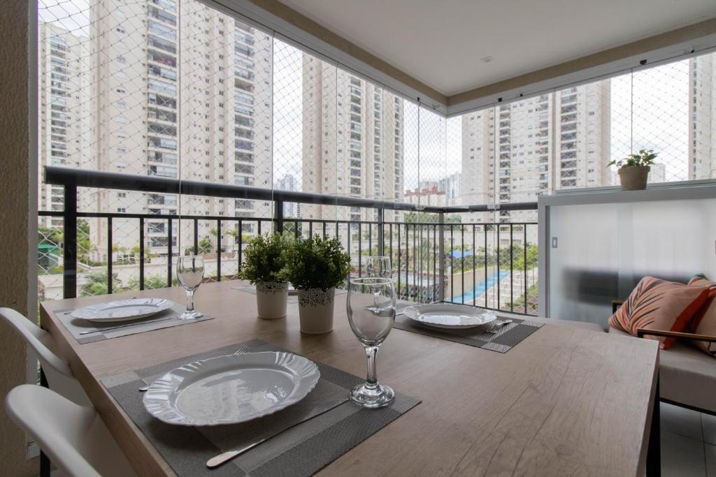 a dining room table with a view of tall buildings at Family Apartment - GRU in Guarulhos