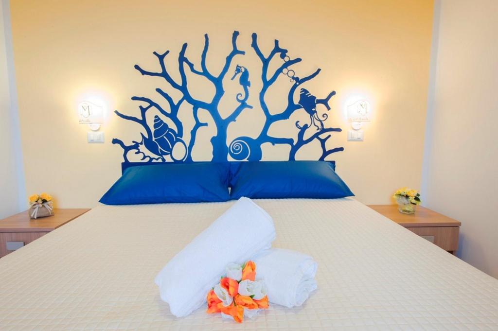 a bedroom with a bed with a tree mural on the wall at Hotel Maremma Sul Mare in Montalto di Castro