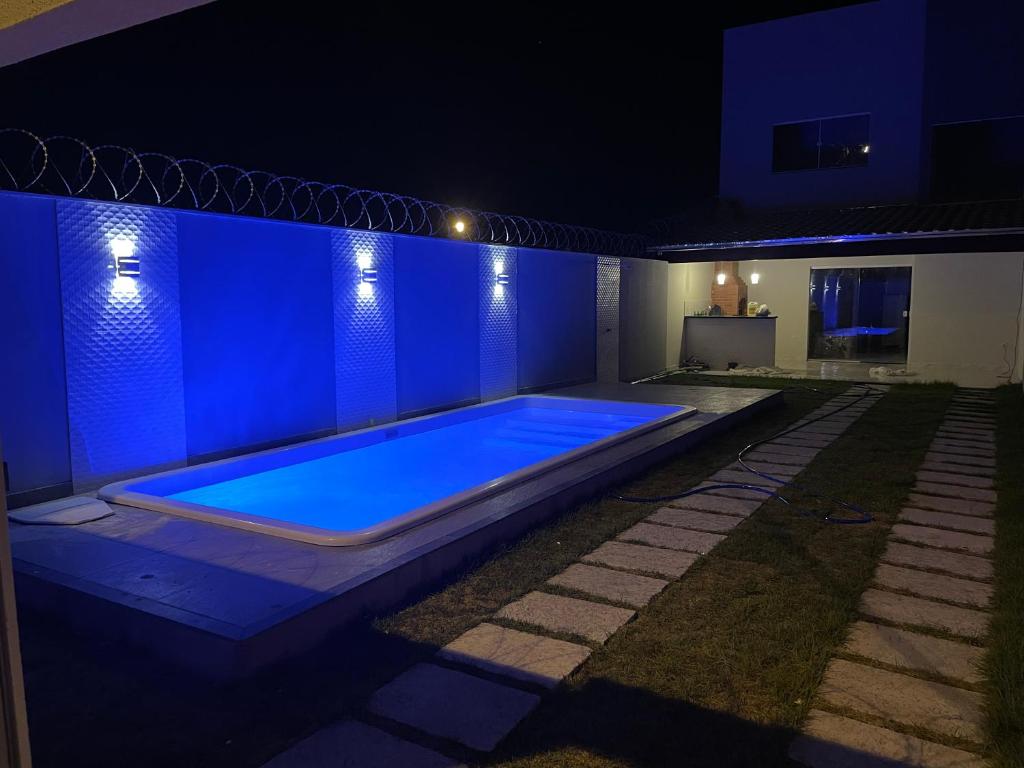 una piscina en medio de una casa por la noche en Duplex Praia do Bosque, en Guriri