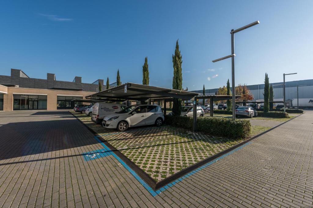 un aparcamiento con coches aparcados bajo una cochera en Hotel Mercader, en Madrid