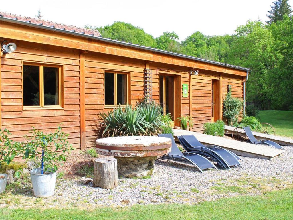 una cabaña de madera con una mesa y sillas frente a ella en Gîte Vernusse, 3 pièces, 6 personnes - FR-1-489-357, en Vernusse