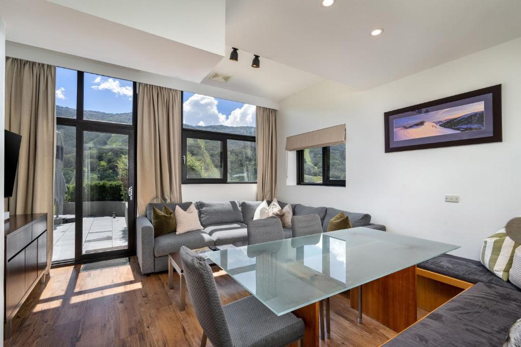 a living room with a glass table and a couch at Lantern 3 Bedroom Terrace with majestic mountain view in Thredbo