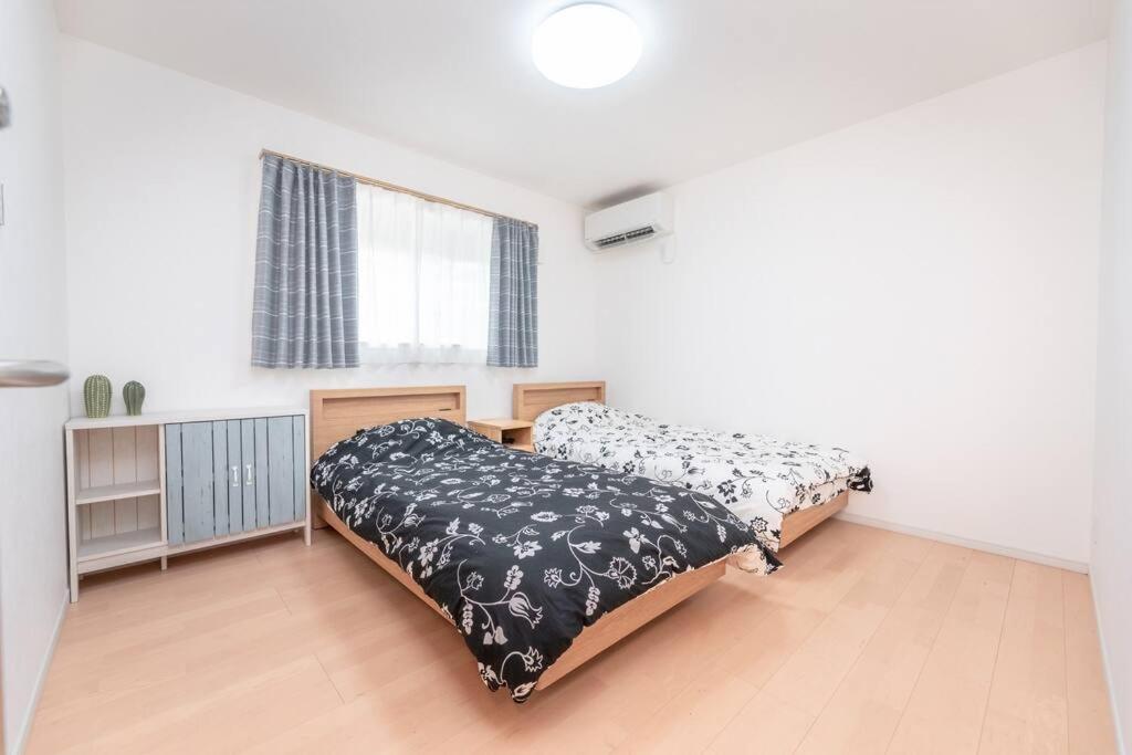 una camera con due letti con lenzuola bianche e nere di 合綠の宿 203 ad Osaka